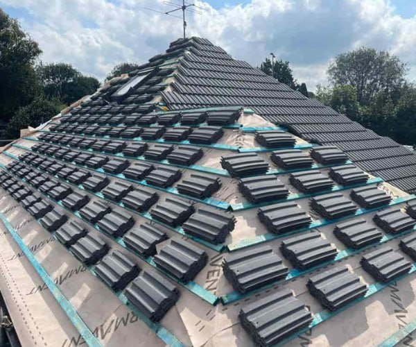 This is a photo of a new hip roof being installed. New felt, battens, and grey tiles have been installed, also a new velux window. Works carried out by DGH Roofing Armthorpe