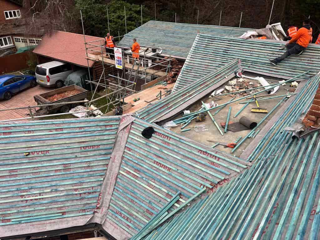 This is a photo of a large re-roof being carried out by DGH Roofing Armthorpe, there are multiple sections of pitched roofs adjoining to a central flat roof